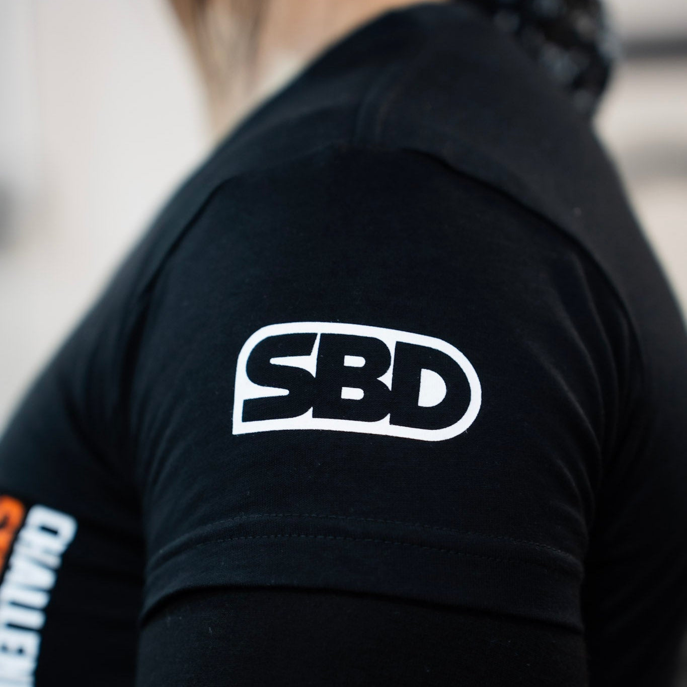Black shirt with 'SBD' logo on the back
