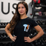 Woman wearing a black t-shirt with a logo in a gym setting